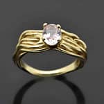 R462 Ondas yellow gold ring is set with an oval-cut pink sapphire